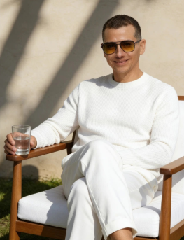 Francisco Lugo sentado en un jardín, vestido de blanco